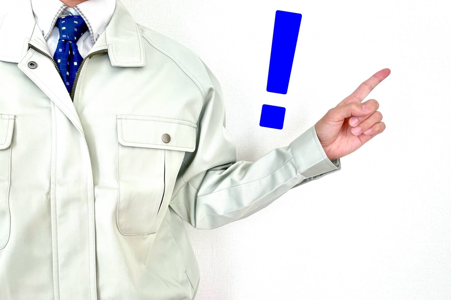 指をさす作業服の男性