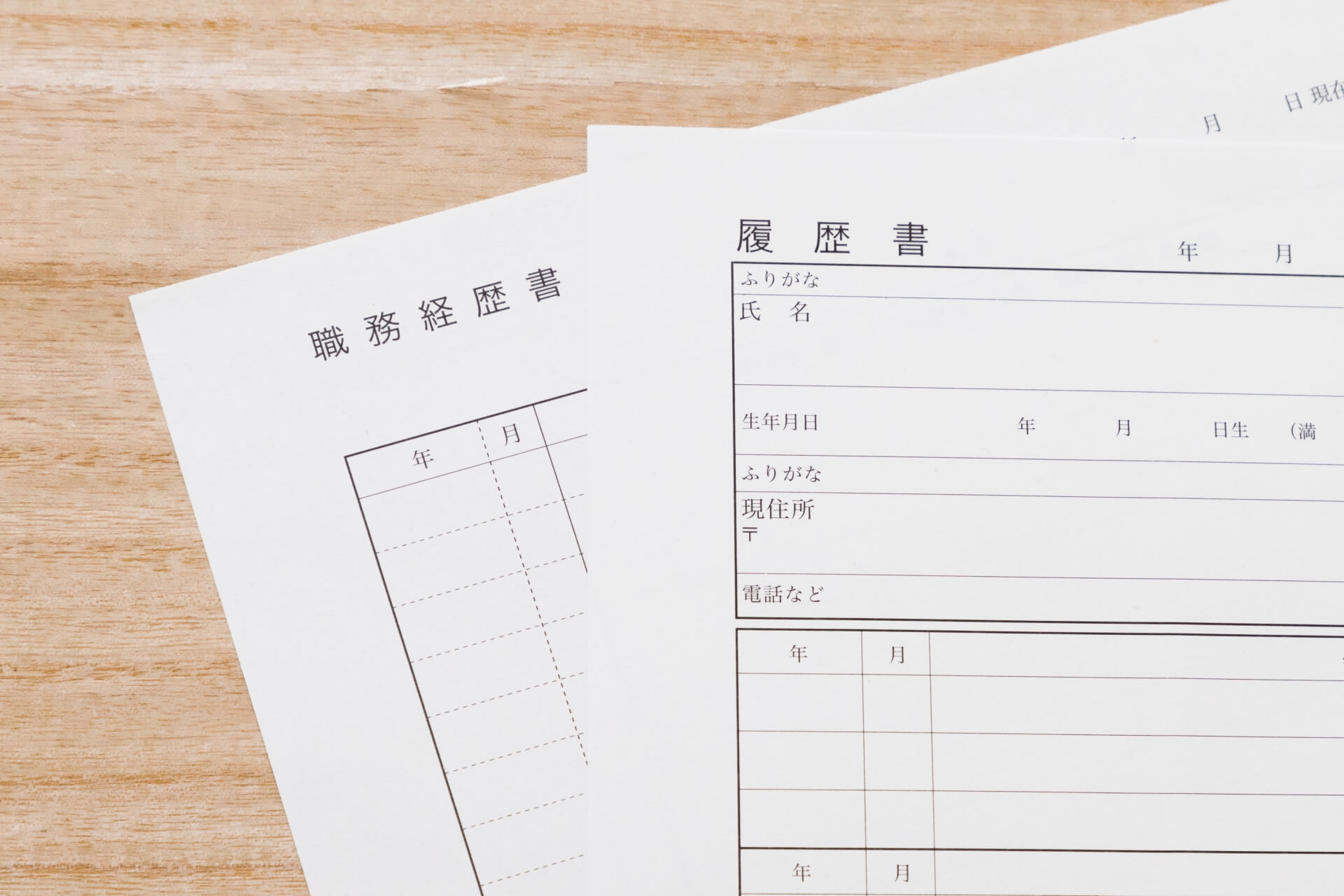 木製テーブルに置かれた履歴書用紙